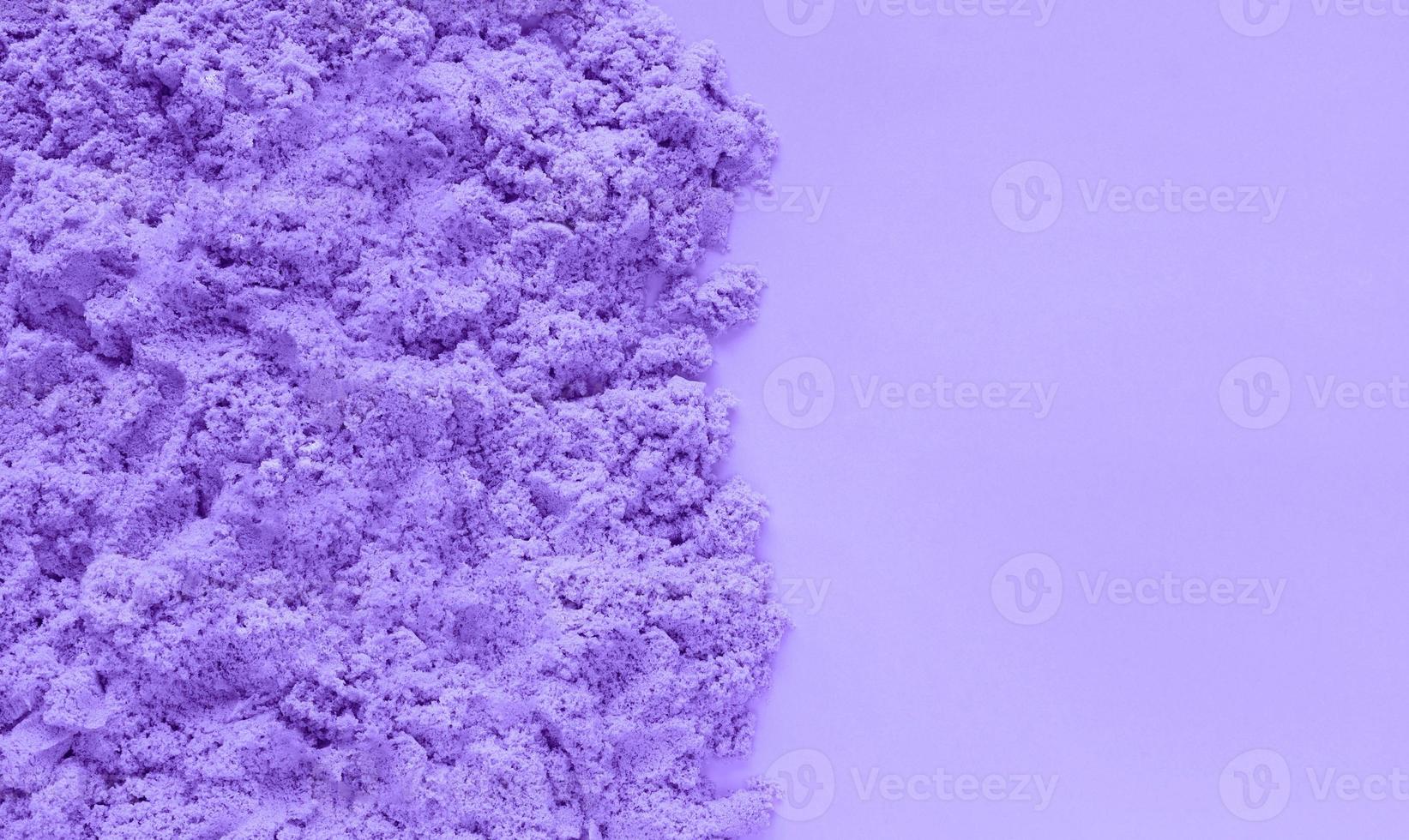 Violet kinetic sand on very peri color paper background with copy space. Early sensory education for children. Kids development concept. Inspired by trendy color of the year 2022 Very Peri. photo