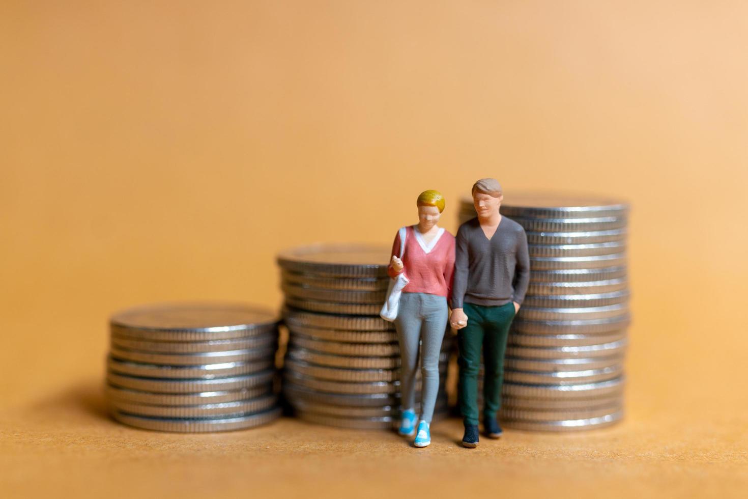 Miniature people, Happy couple standing on coins stack photo