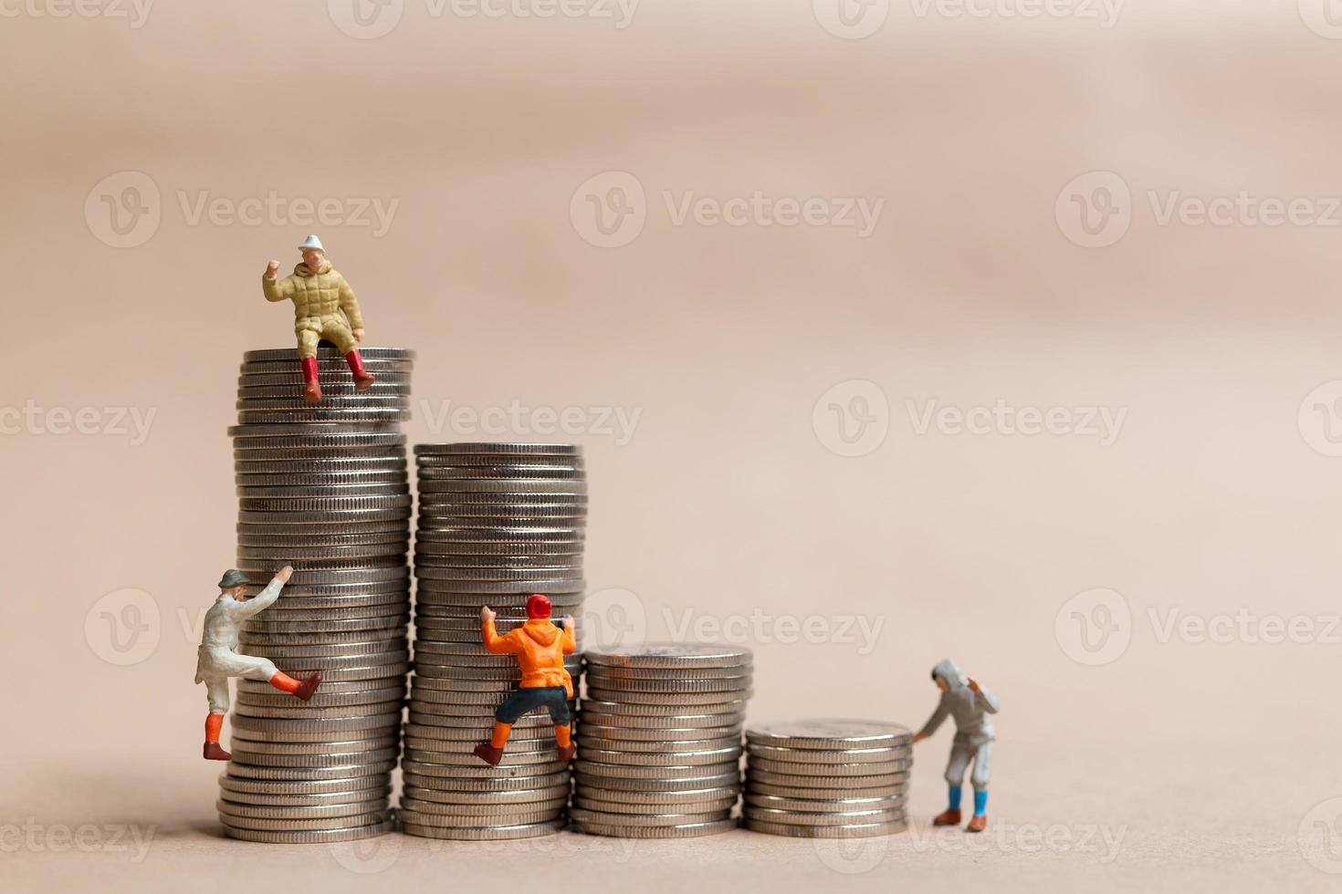 Miniature people Mountain climber ascending the coin stack photo