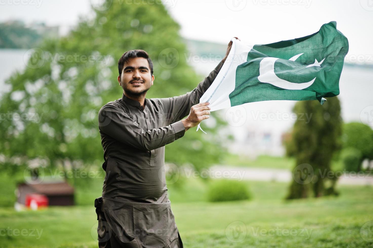 Indo pakistani man wear traditional clothes achkan or sherwani with Pakistan flag. photo