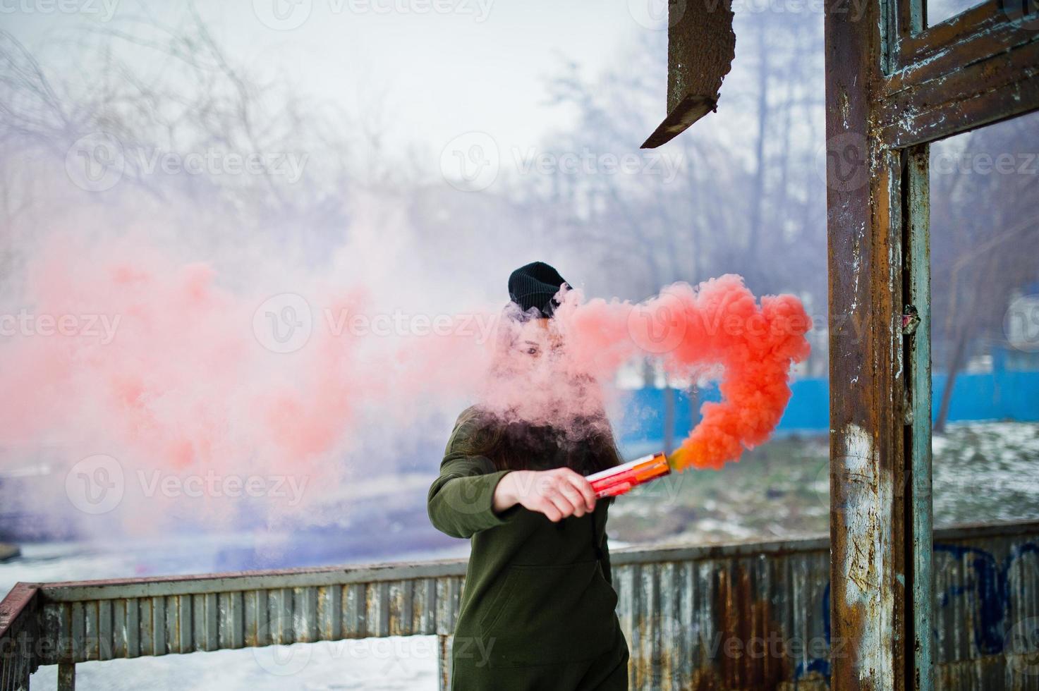 Young girl with blue and red colored smoke bomb in hands. photo