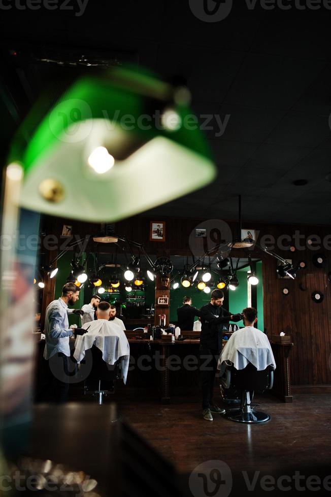 Handsome bearded man at the barbershop, barber at work. photo