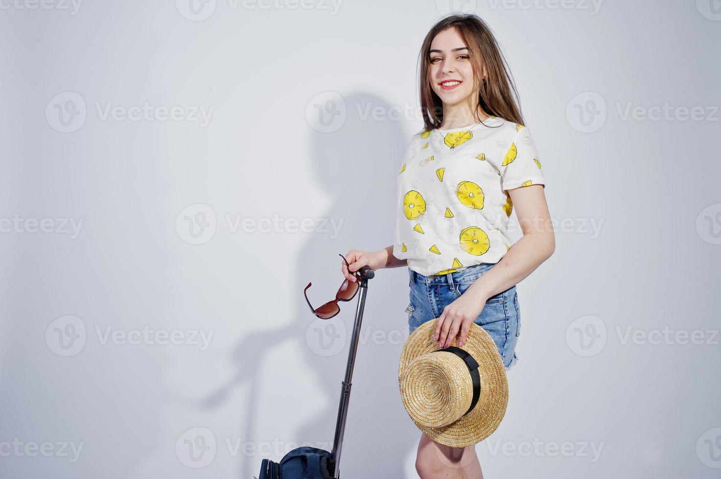 chica turista con bolso, vestido con camisa, pantalones cortos y sombrero con gafas aislado en blanco. foto