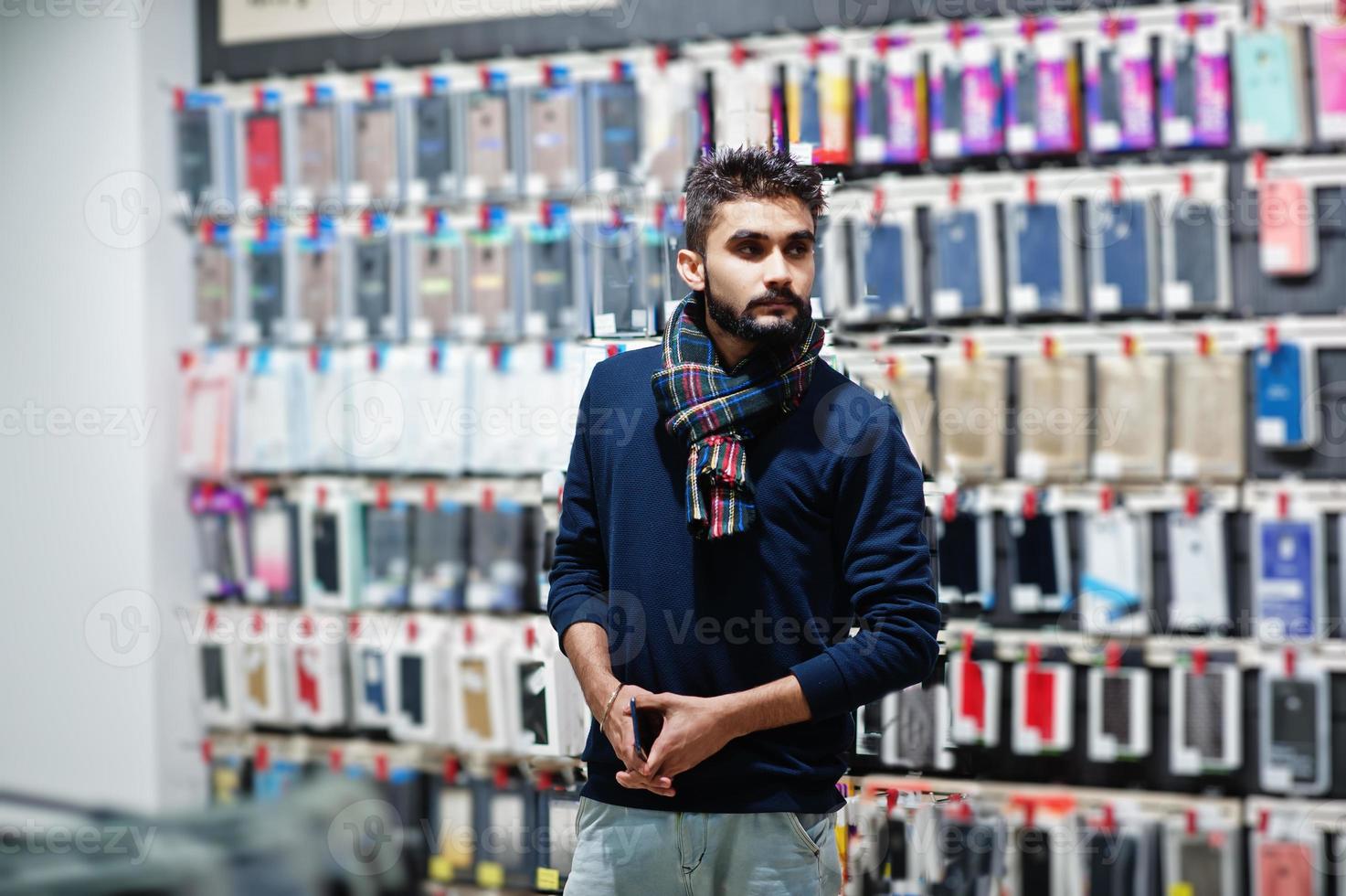 Indian beard man customer buyer at mobile phone store choose a case for his smartphone. South asian peoples and technologies concept. Cellphone shop. photo