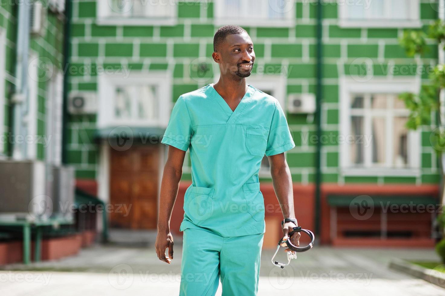 retrato de un médico africano con estetoscopio con abrigo verde. foto