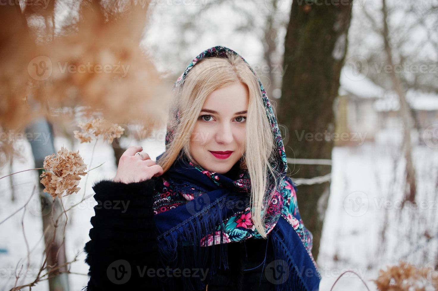 chica rubia con bufanda bordada a mano posada en el día de invierno. pañuelo de mujer. foto