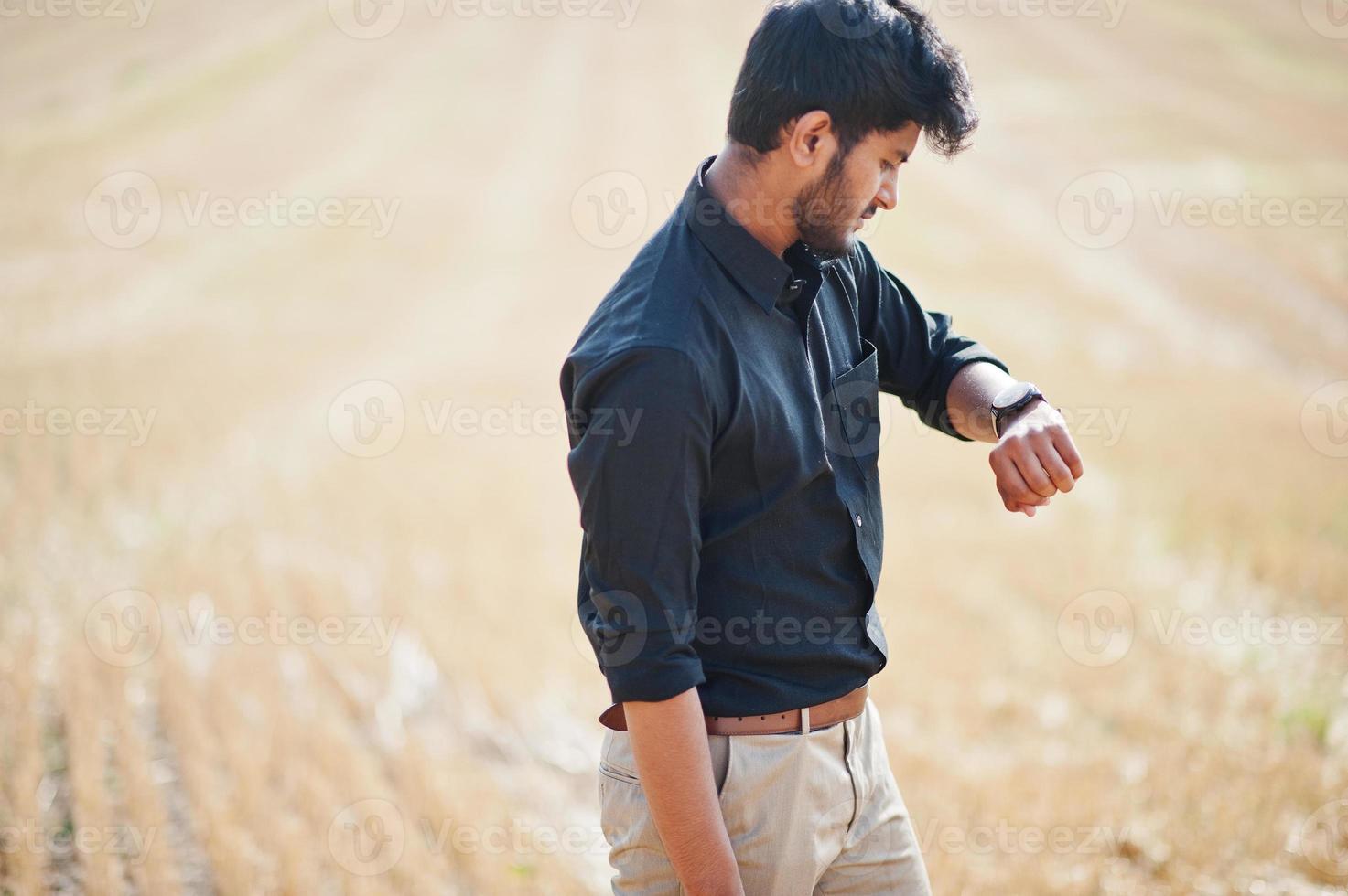 South asian agronomist farmer inspecting wheat field farm. Agriculture production concept. photo