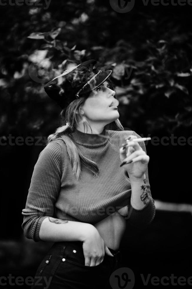 retrato de moda de chica sexy pelirroja al aire libre. modelo atractiva mujer de seducción con cigarrillo. foto