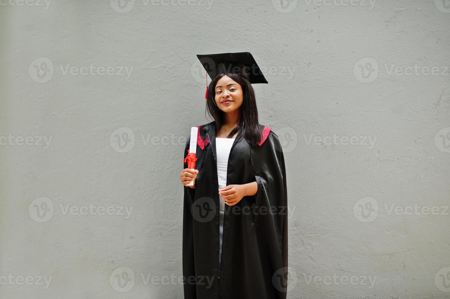 joven estudiante afroamericana con diploma posa al aire libre. foto