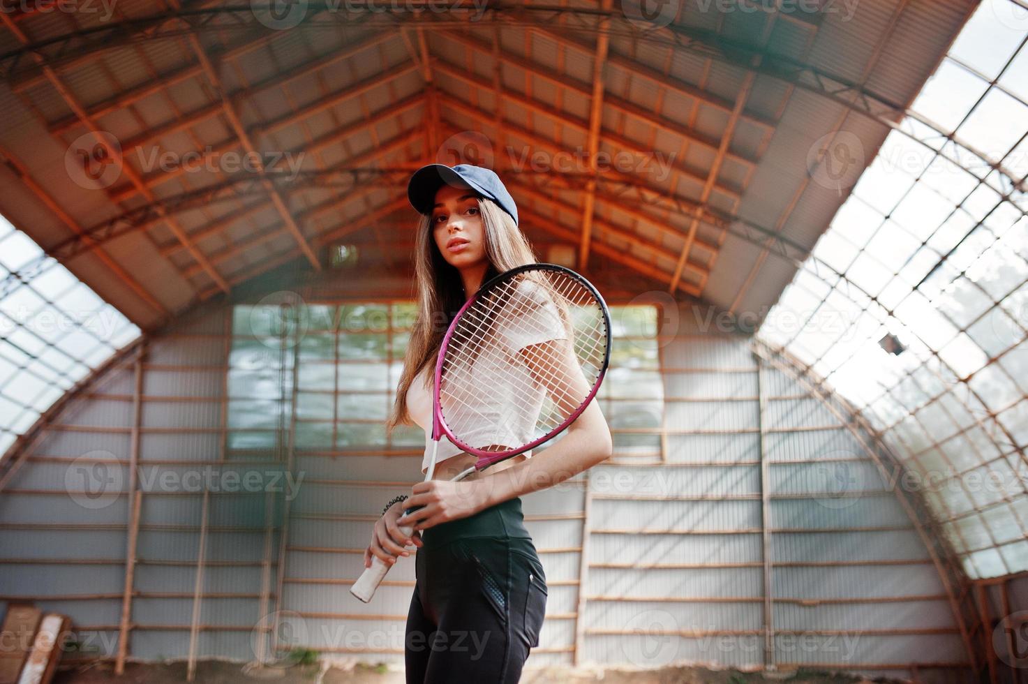 Young sporty girl player with tennis racket on tennis court. photo