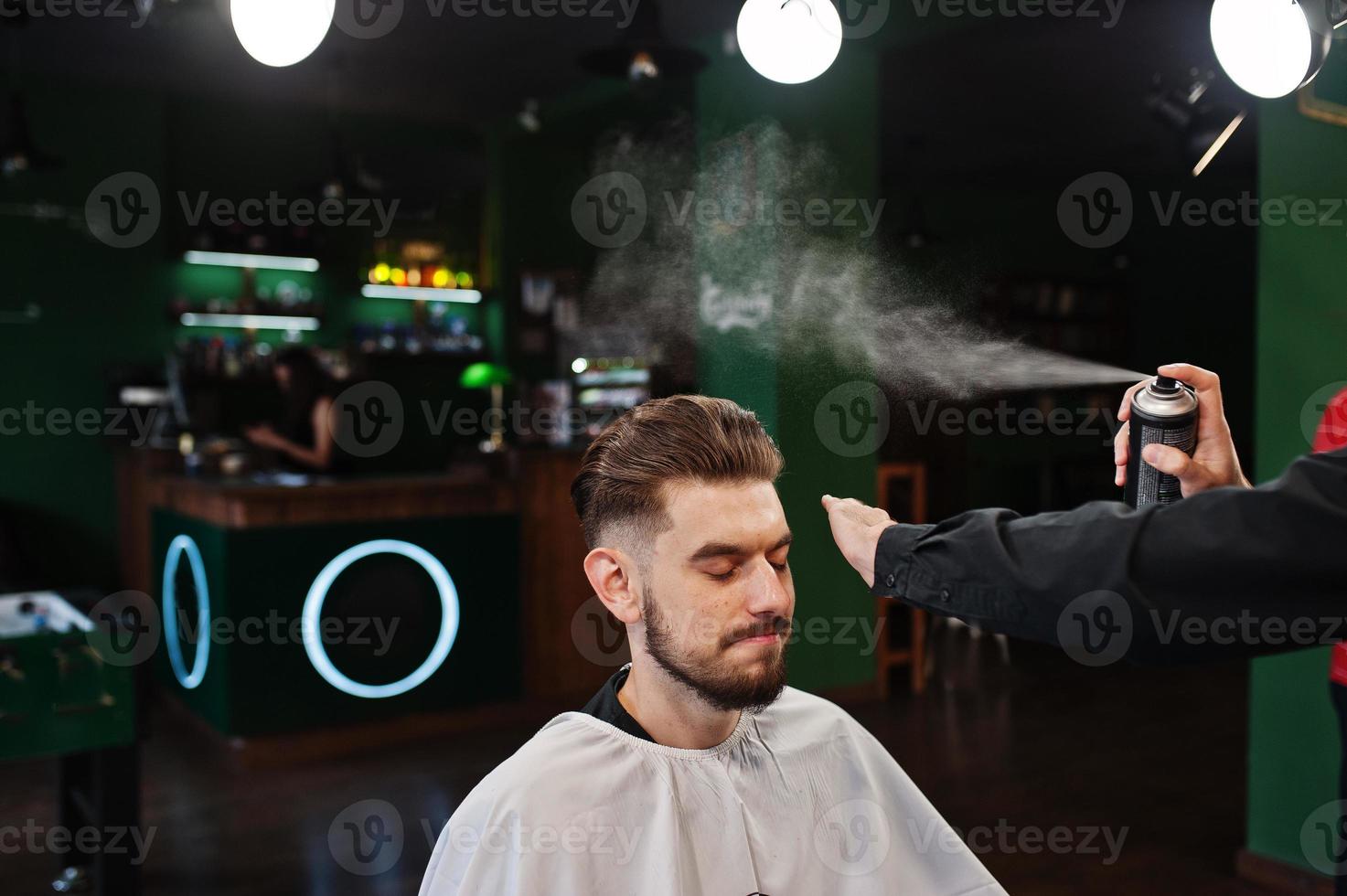 Handsome bearded man at the barbershop, barber at work. photo