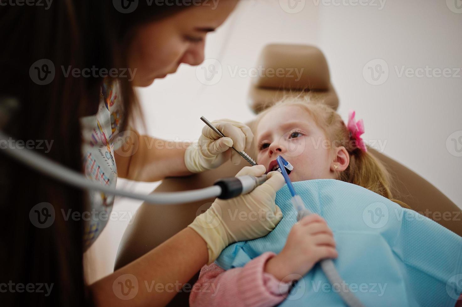 Little baby girl at dentist chair. Children dental. photo