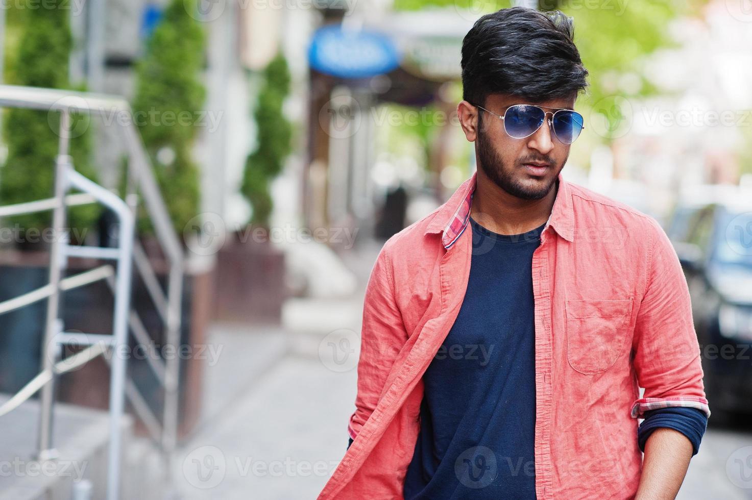 Portrait of young stylish indian man model pose in street in sunglasses. photo