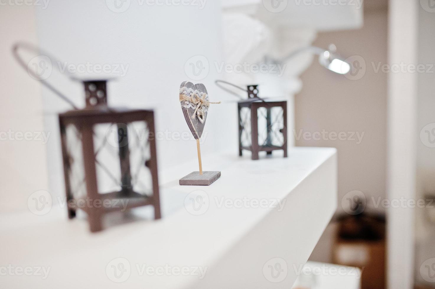Close-up photo of lanterns and a wooden heart on the self.