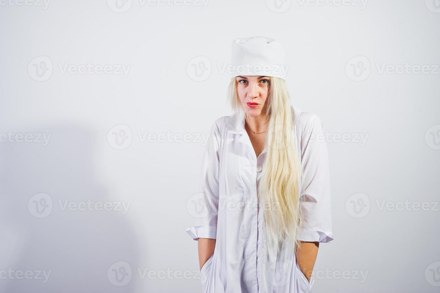 Attractive blonde female doctor or nurse  in lab coat isolated on white background. photo