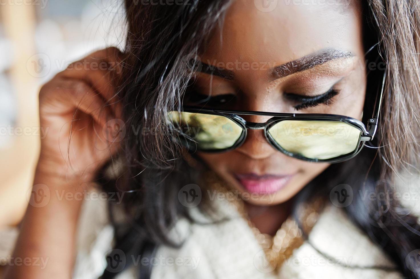 Close up face of african american girl in sunglasses posed at modern cafe . photo