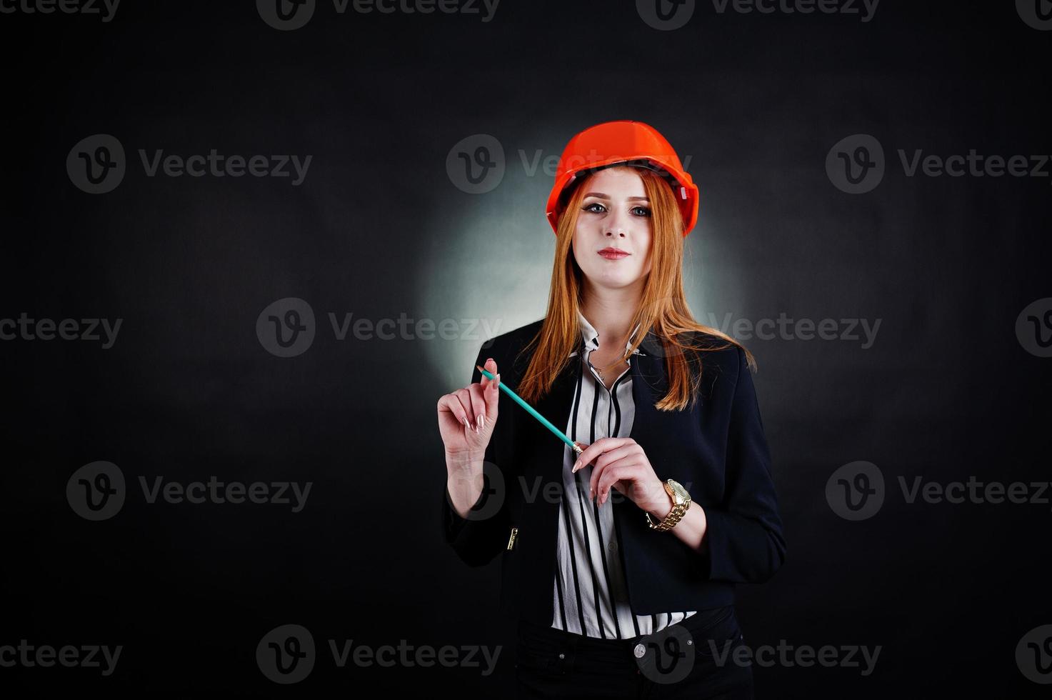 Engineer woman in orange protect helmet with pensil. photo