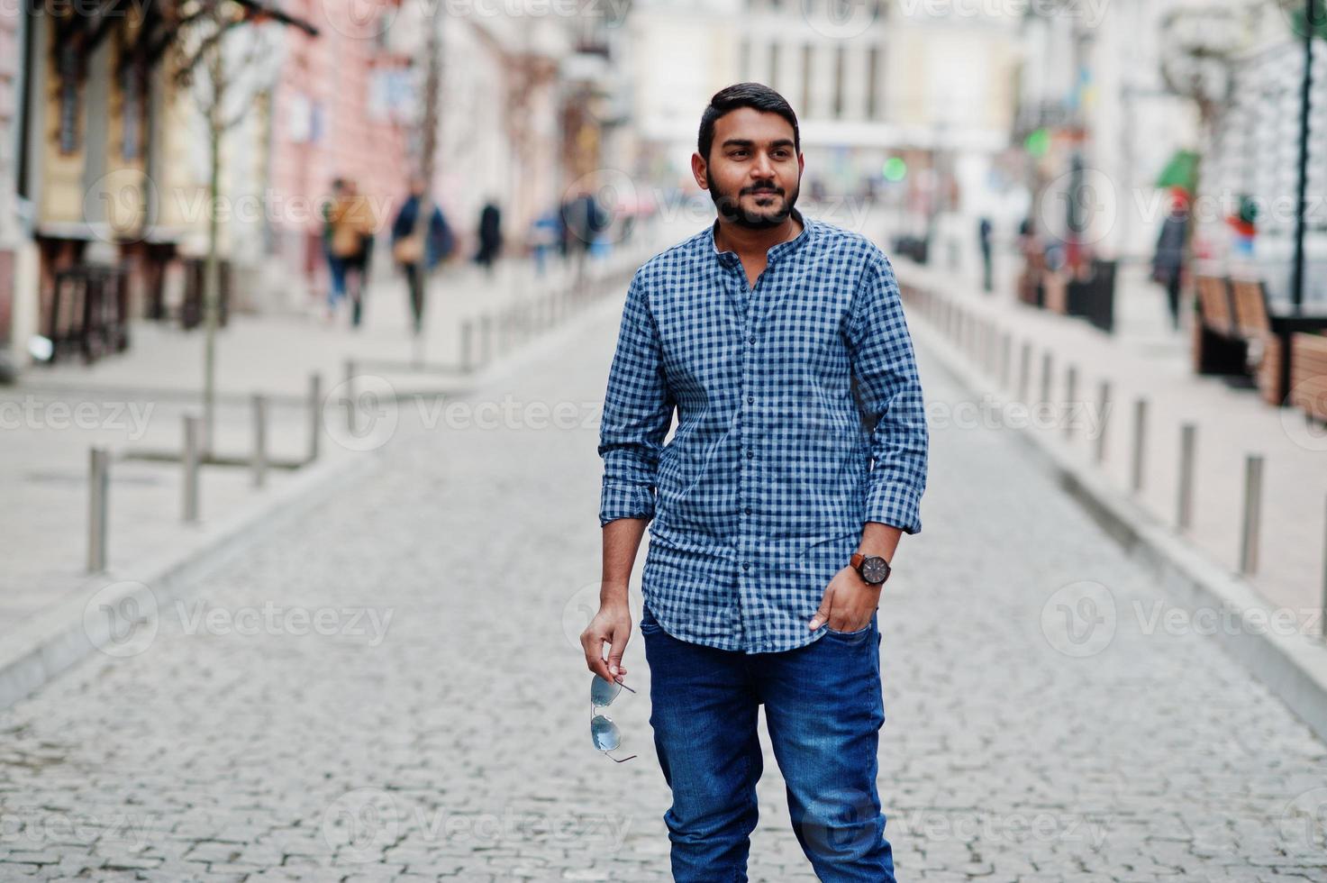 Stylish indian beard model man in casual clothes posed outdoor at street of India. photo