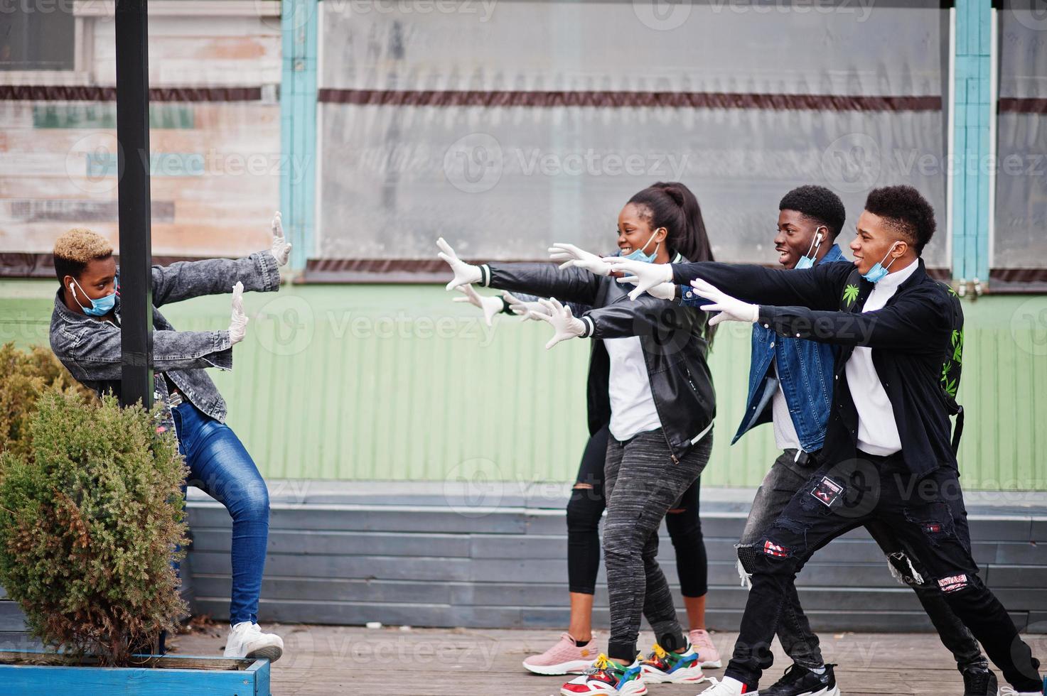 Group of african teenagers friends at park wearing medical masks protect from infections and diseases coronavirus virus quarantine. photo