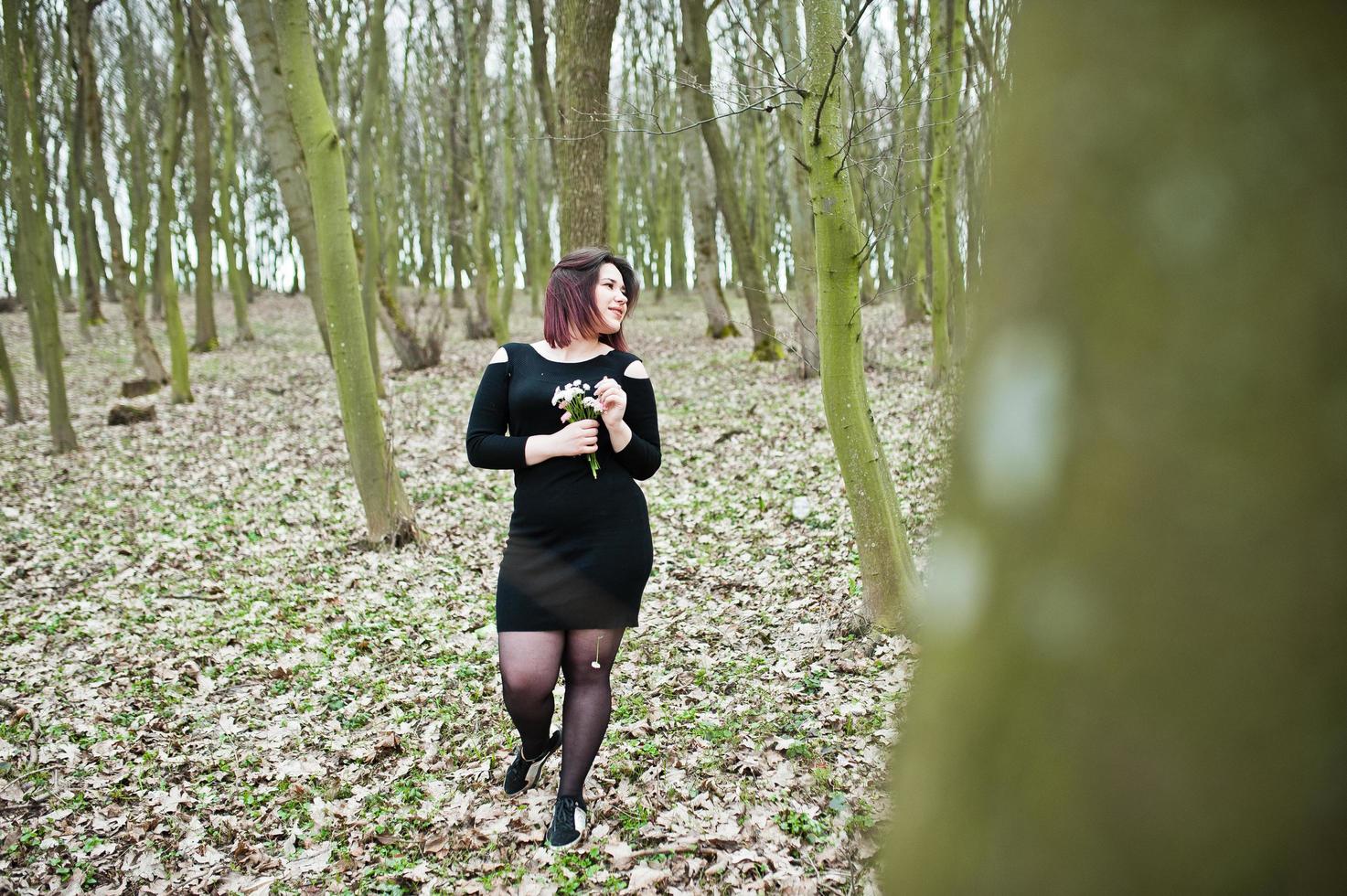 retrato de una chica morena vestida de negro en madera de primavera. foto