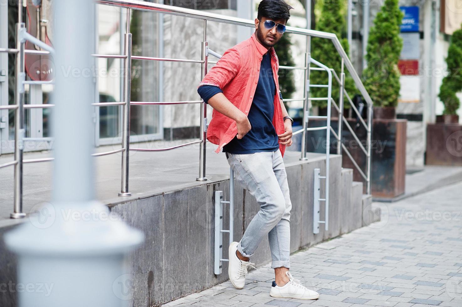 Portrait of young stylish indian man model pose in street in sunglasses. photo