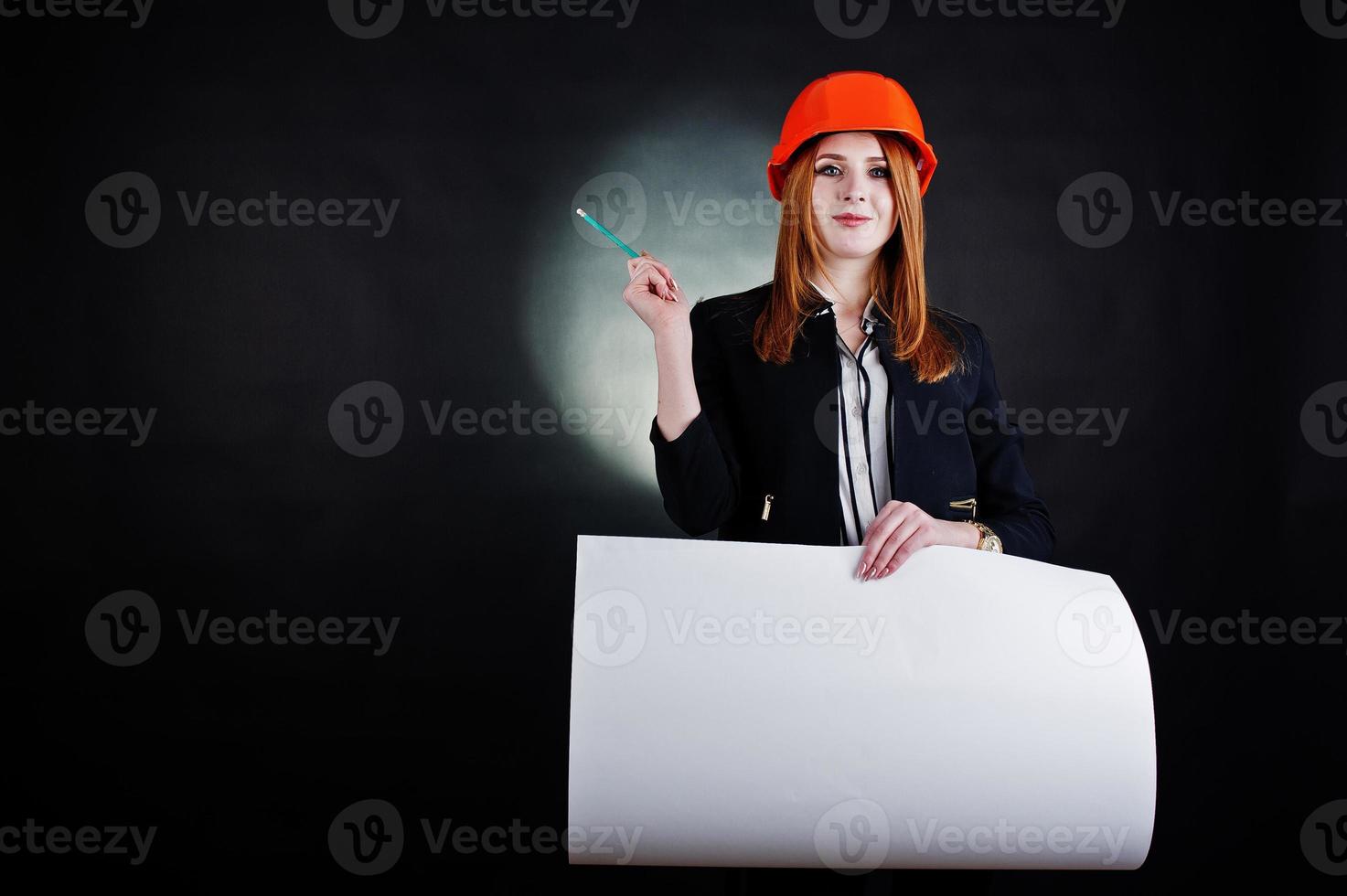 Engineer woman in orange protect helmet with construction paper projekt. photo