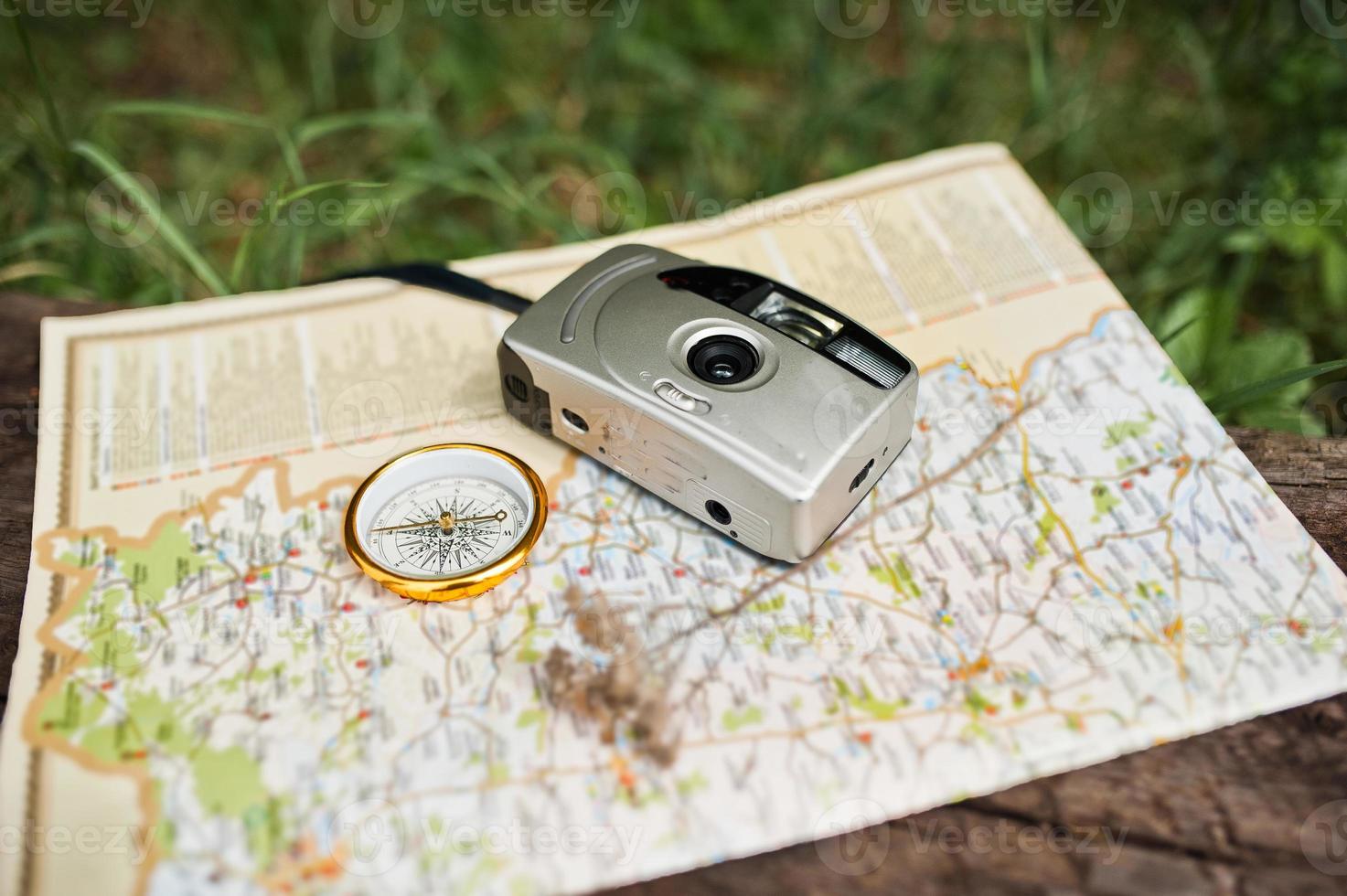 Close-up photo of compass laying on the map next to the camera.