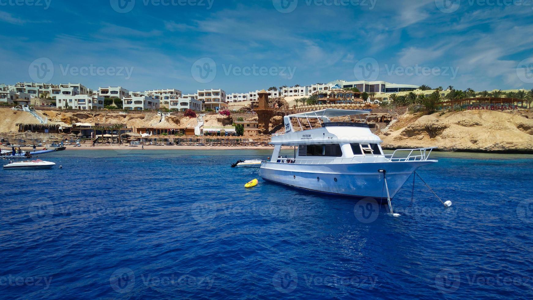 Sharm El Sheikh  marina in Egypt, daylight panoramic view in summer with yachts in water, hotels in background and clouds in the sky photo