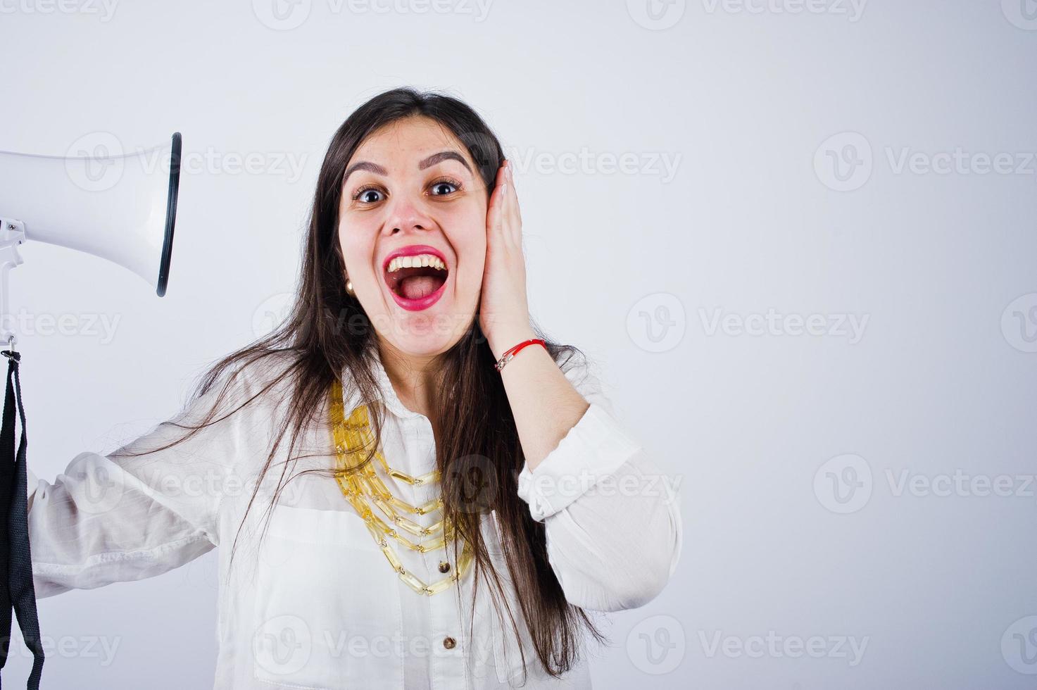 Close-up portrait of a woman covering her ears because of the megaphone. photo