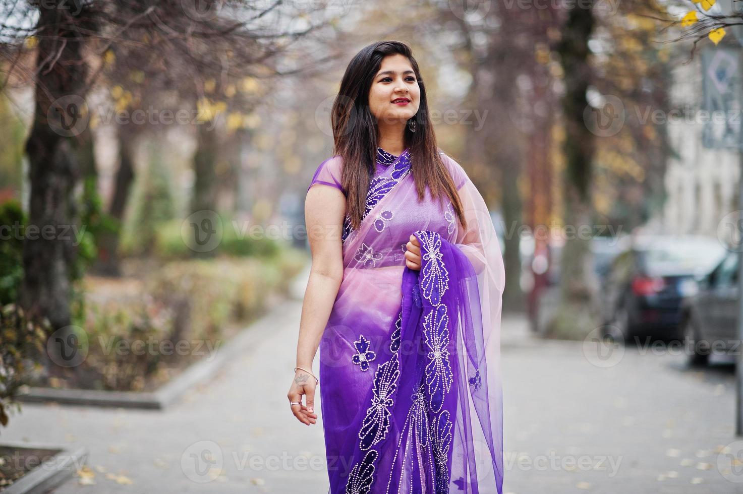 Indian hindu girl at traditional violet saree posed at autumn street. photo