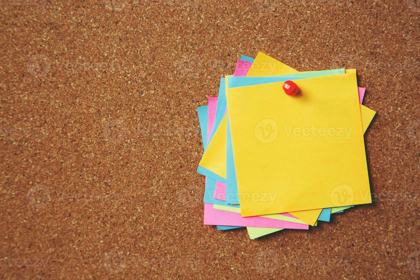 coloridas notas adhesivas en el tablón de anuncios de corcho foto