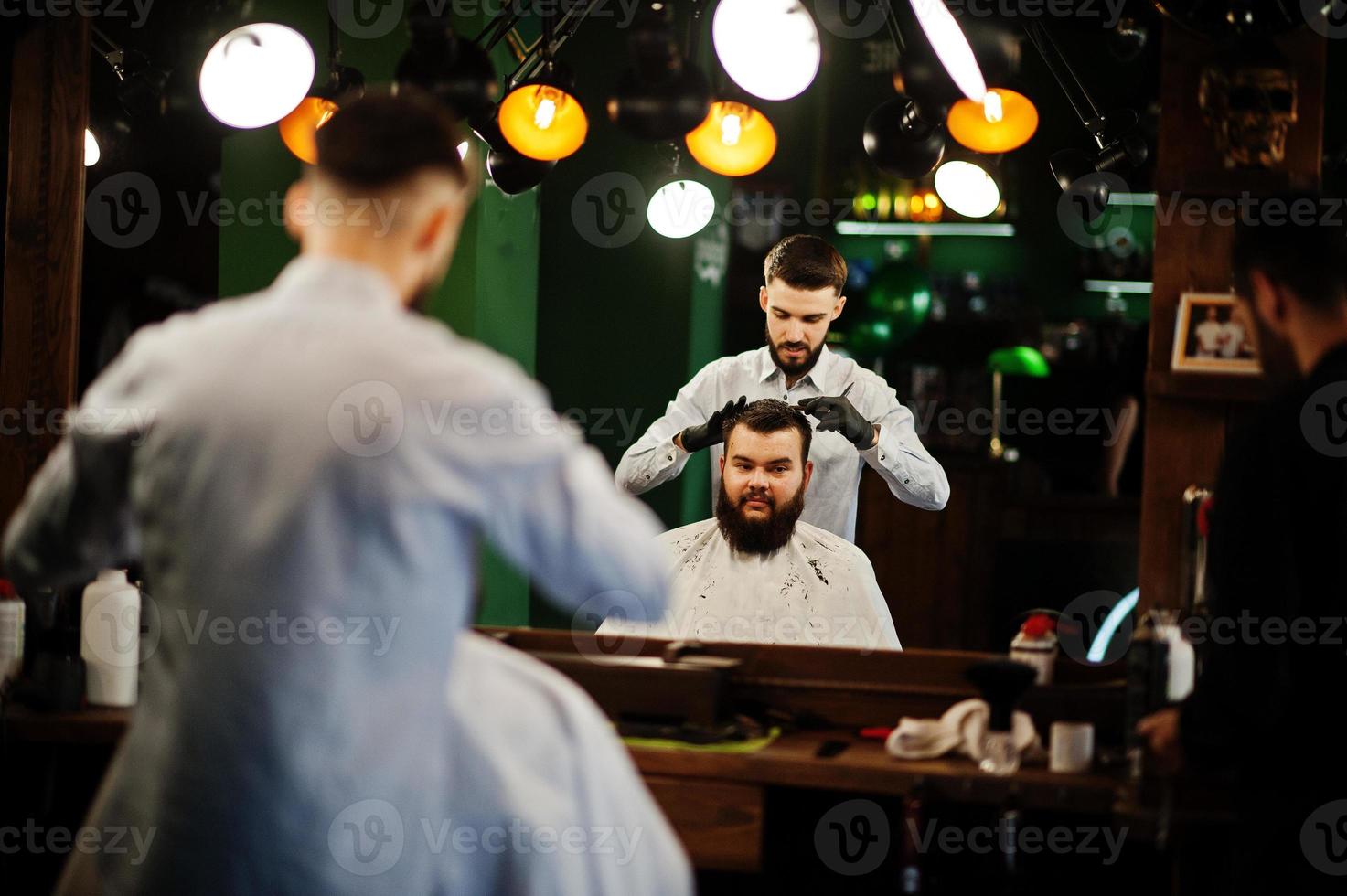 apuesto hombre barbudo en la barbería, peluquero en el trabajo. foto