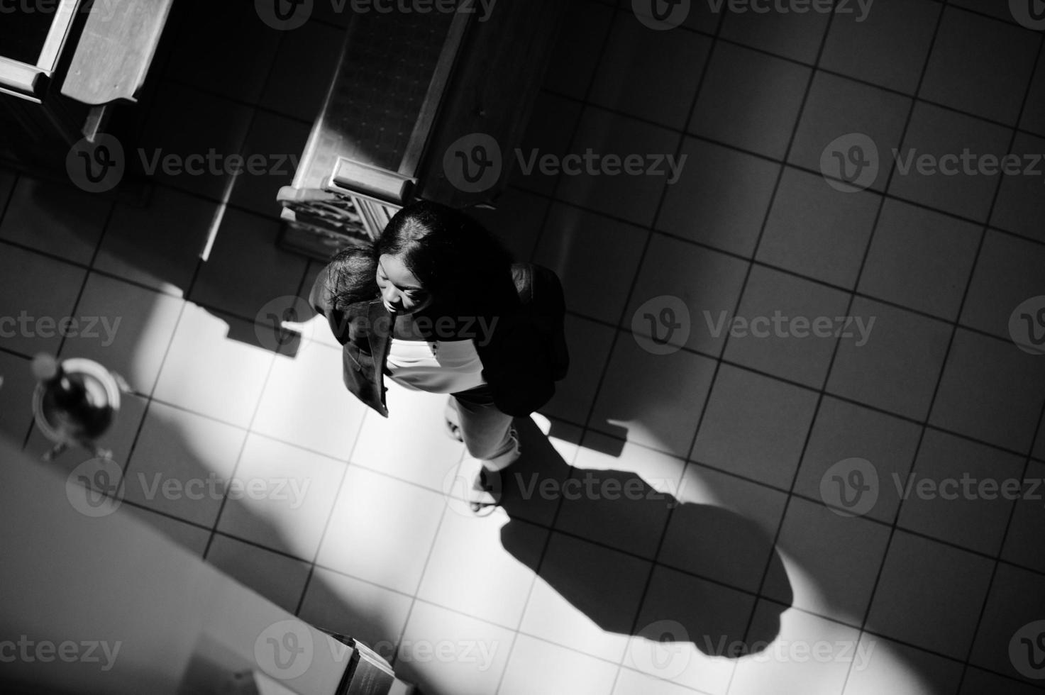 African american woman praying in the church. Believers meditates in the cathedral and spiritual time of prayer. View from above. photo