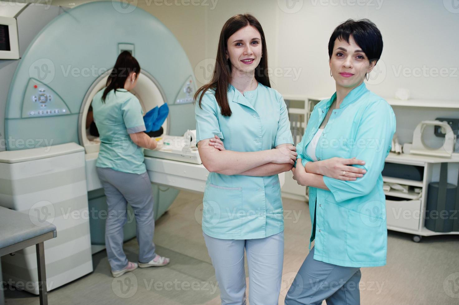 Three female doctors near resonance imaging machine with
