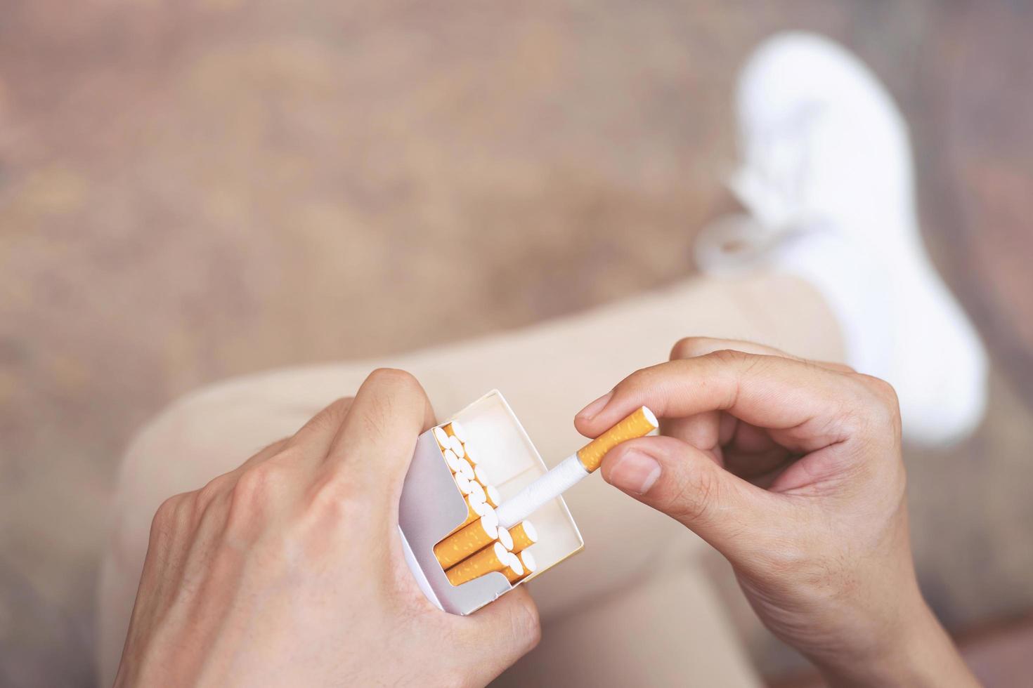 close up man hand holding peel it off cigarette pack prepare smoking a cigarette. Packing line up. photo filters Natural light.