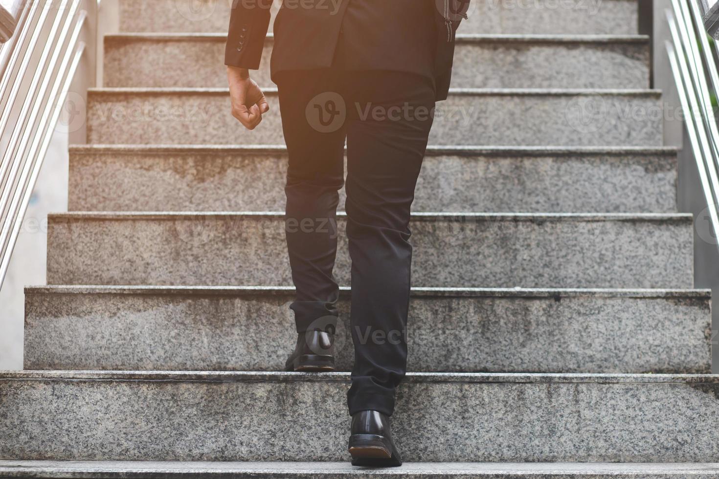 hombre de negocios moderno trabajando piernas de primer plano subiendo las escaleras en la ciudad moderna. en hora punta para trabajar en la oficina de prisa. durante la primera mañana de trabajo. escalera foto