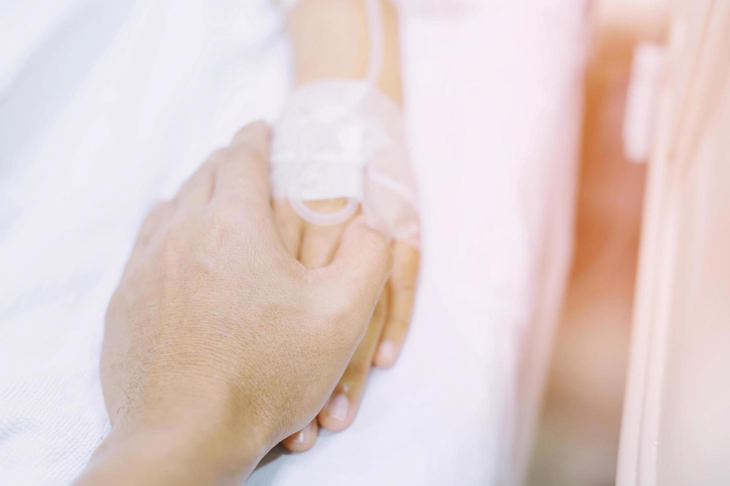 centrarse en la mano de un paciente en la sala del hospital foto