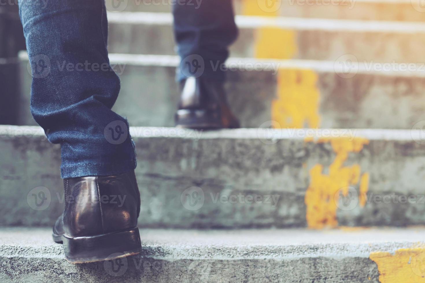 hombre de negocios moderno trabajando piernas de primer plano subiendo las escaleras en la ciudad moderna. en hora punta para trabajar en la oficina de prisa. durante la primera mañana de trabajo. escalera. foto