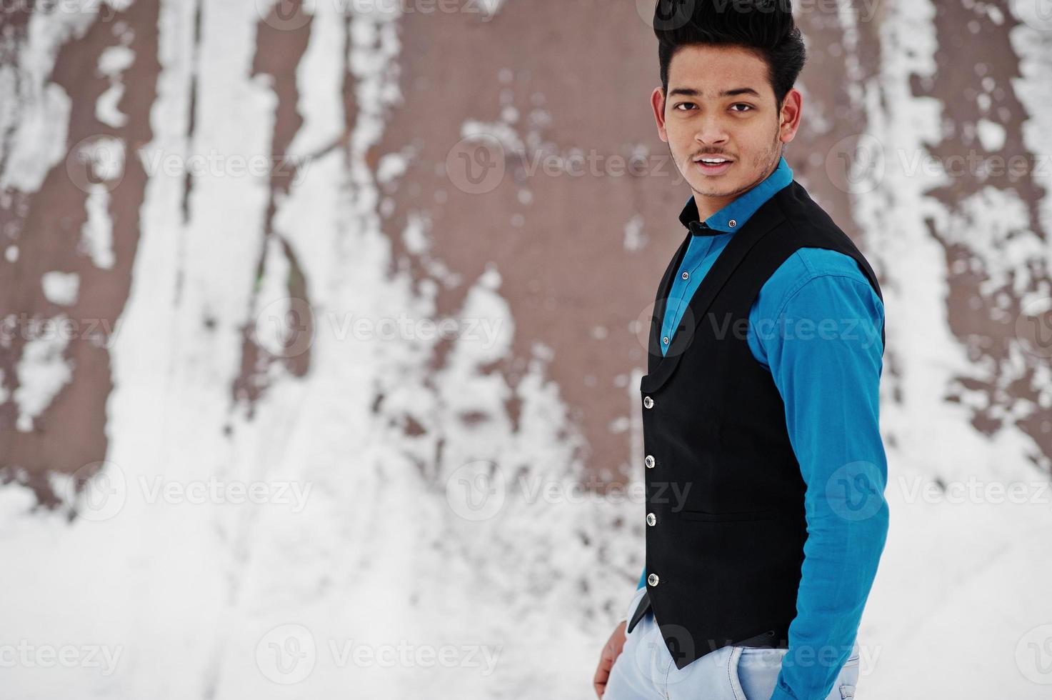 un joven indio casual con camisa azul y chaleco negro posó en el día de  invierno. 10573387 Foto de stock en Vecteezy