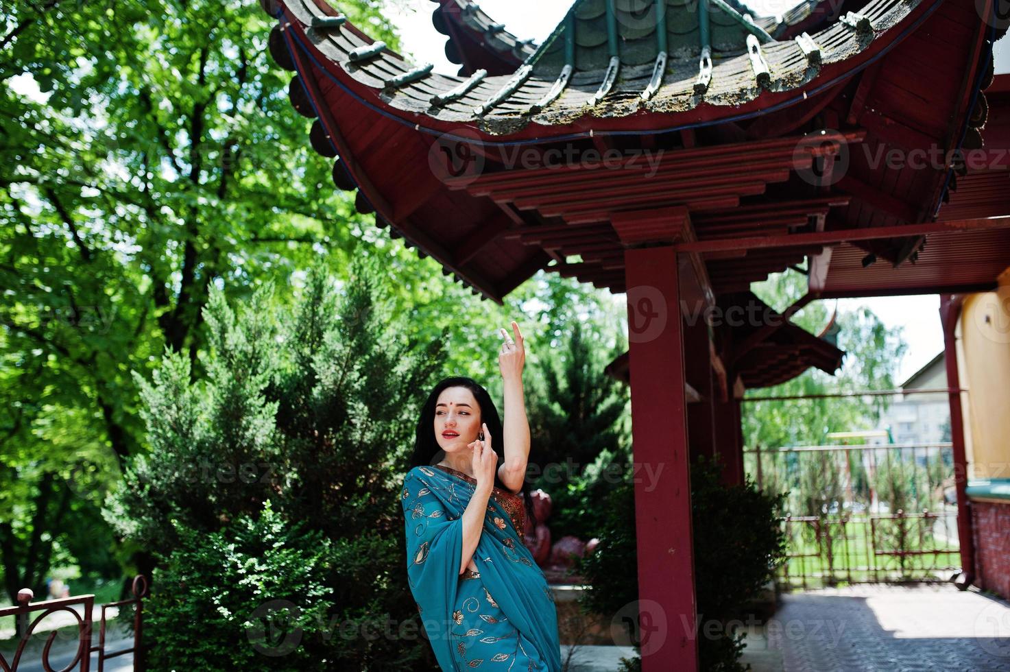 Portrait of beautiful indian brumette girl or hindu woman model against japanese traditional house. photo