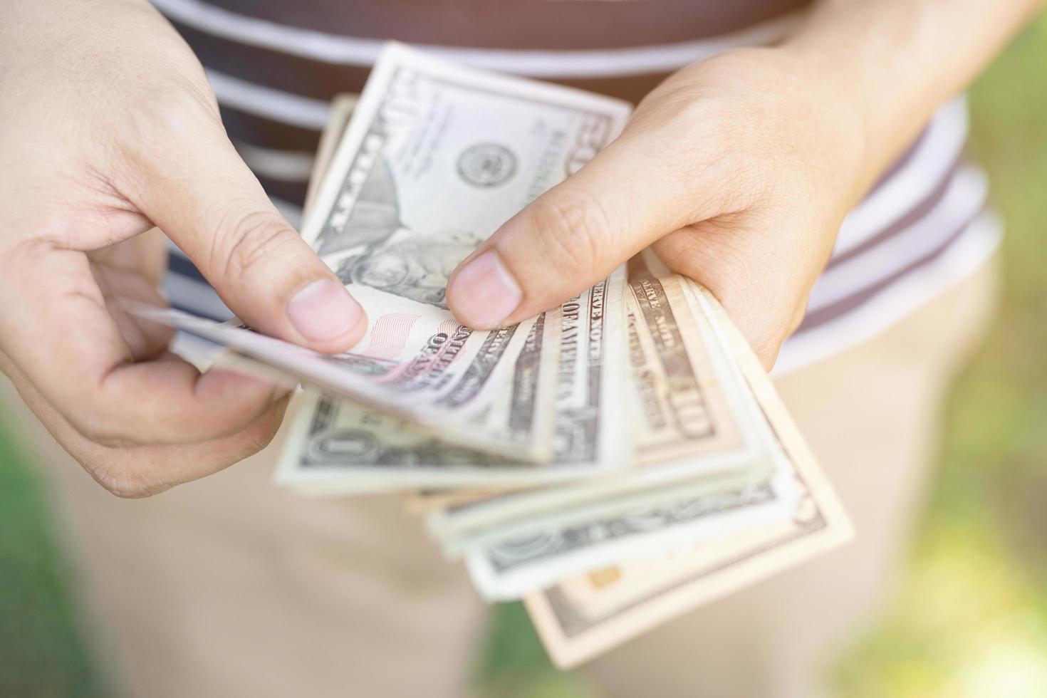 close up young man standing  hand hold Count the money spread of cash. concept finance Saving money. photo