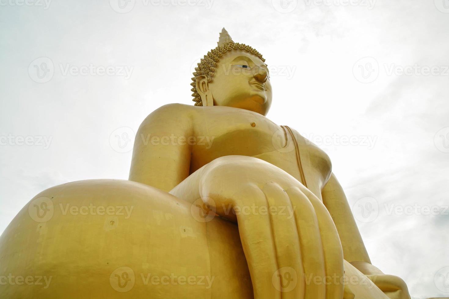 The biggest golden buddha statue in Wat Muang at Angthong province, thailand on sky background. photo