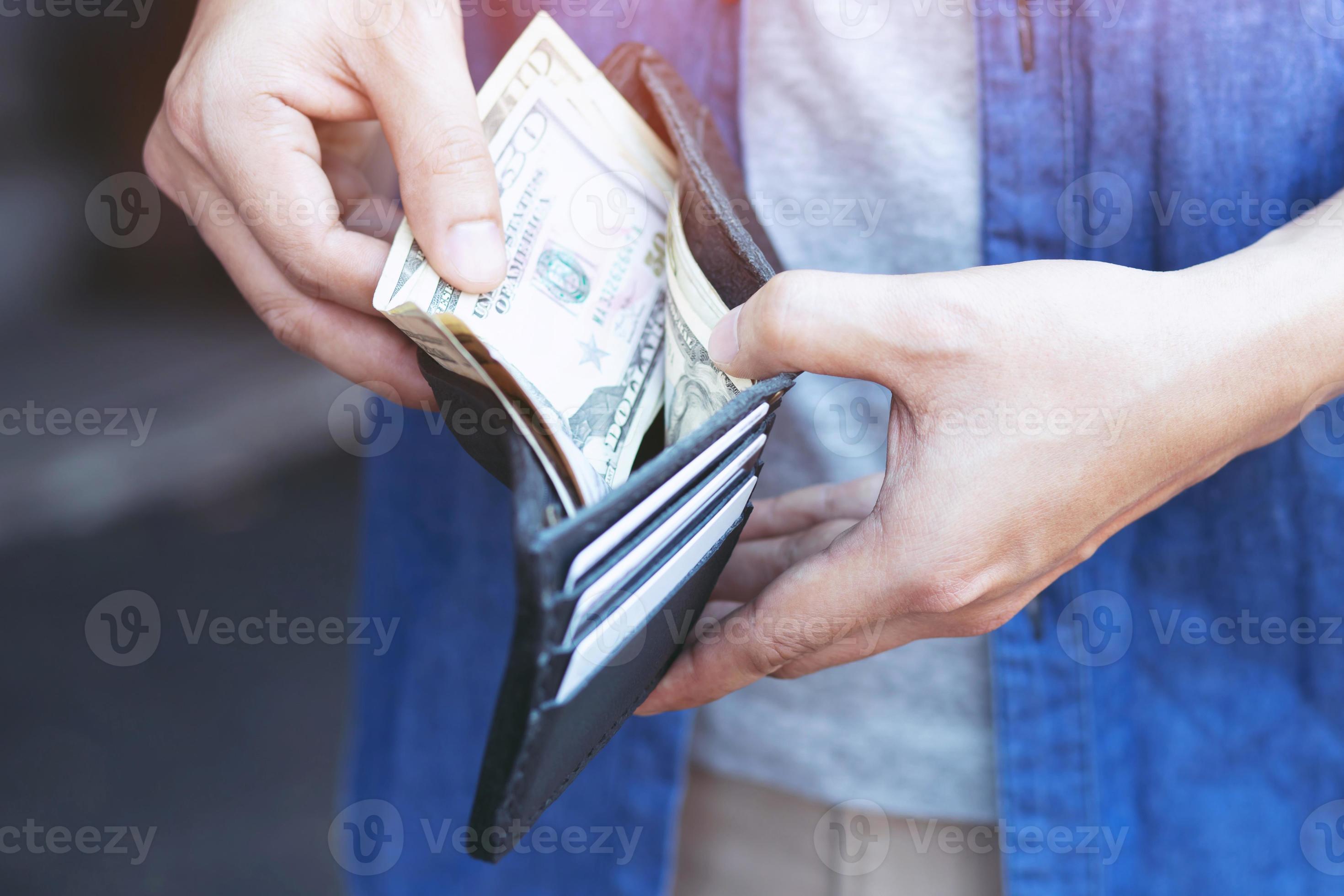 Man standing holding black wallet full of money 10573976 Stock Photo at