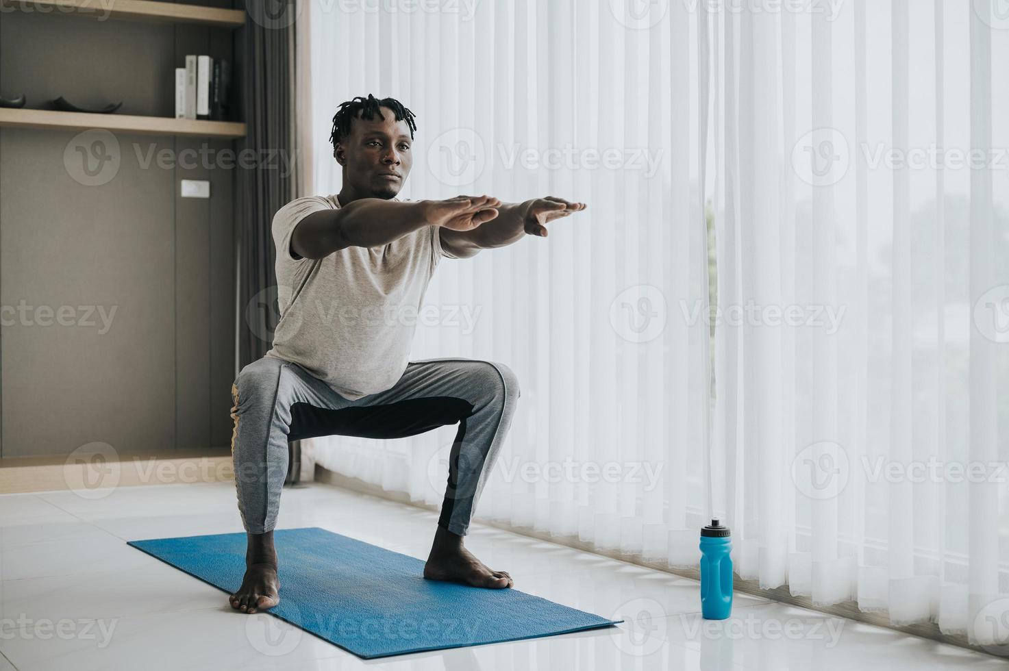 African man doing squat exercise photo