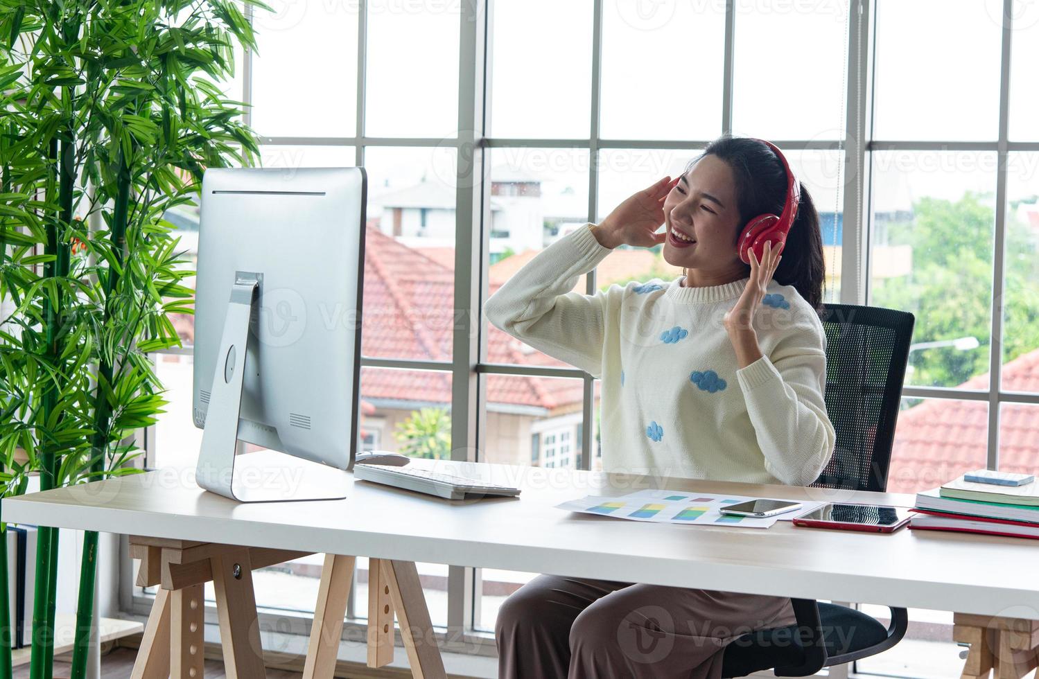 Work from home and online learning or meeting concept. Pretty young women working on computer using smartphone in the living room or co-working space. photo