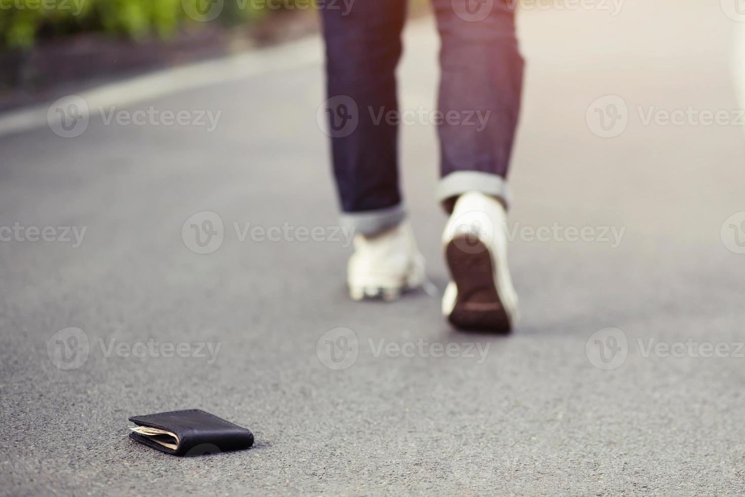 businessman had lost leather wallet with money on the street. Close-up of wallet lying on the sidewalk in during the trip to work. photo