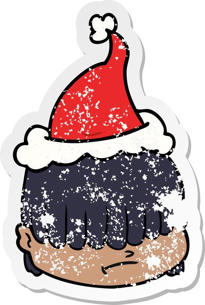 distressed sticker cartoon of a face with hair over eyes wearing santa hat vector