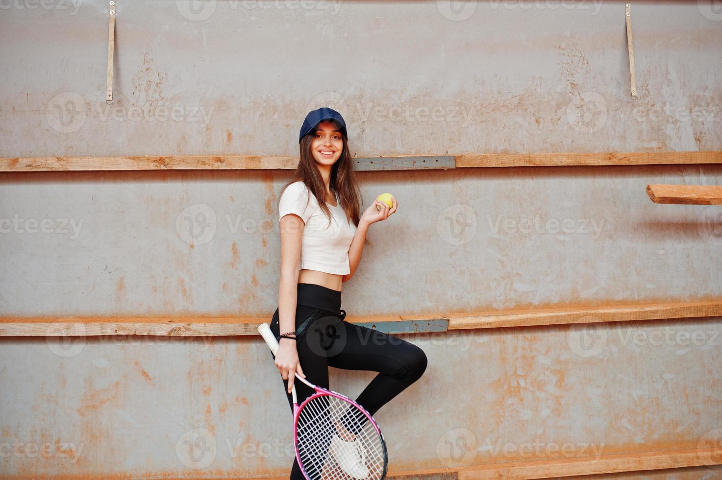 Young sporty girl player with tennis racket on tennis court. photo