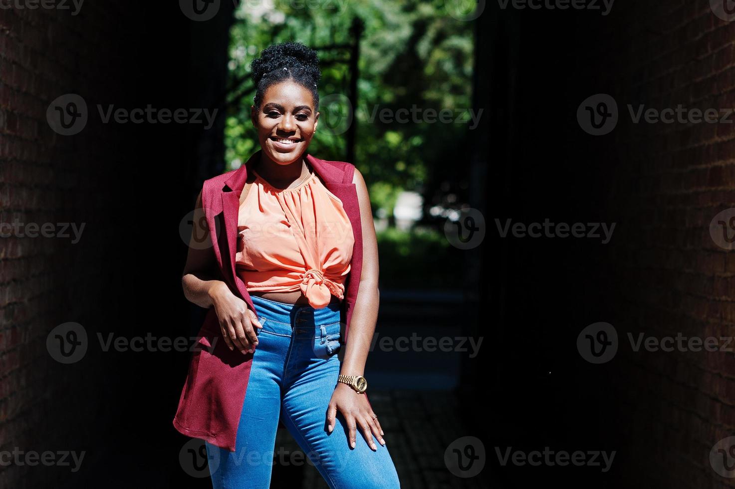 elegante mujer afroamericana posada en arco tonnel en un día soleado. foto