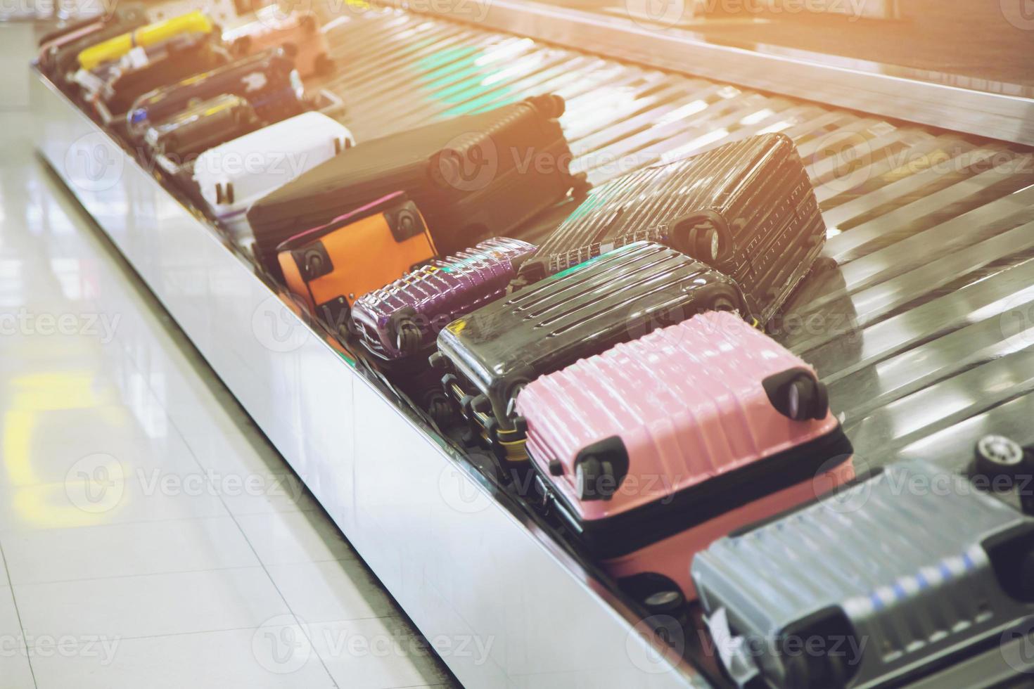 Suitcase or luggage with Circulating conveyor belt in the baggage claim in the international airport. photo